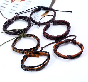 Detail showing set of six braided leather bracelets in brown, black, and green tones