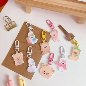 Flat lay of cute acrylic cartoon bear and rabbit keychains with colorful plastic clips