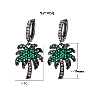 Detail view of tropical palm tree earrings with green zircons and measurement scale
