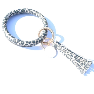 Detail of leopard print leather keychain bracelet with tassel and gold metal spring buckle