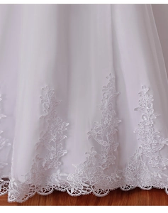 Detailed view of intricate lace embroidery and floral scalloped hem on white bridal gown