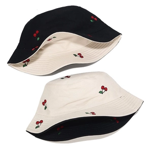 Detail showing dual-sided reversible design with cherry embroidery on bucket hat