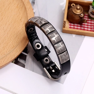 Detail of vintage black leather bracelet with metal plate and adjustable buckle