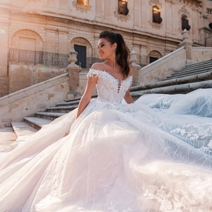 Elegant white off-shoulder ball gown wedding dress with lace embroidery and long train
