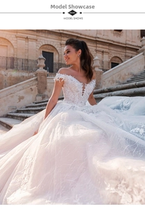 Exquisite close-up of ivory lace embroidery and deep V-neckline on a long train wedding gown