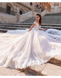 Exquisite close-up of bridal lace embroidery and intricate textures on a white wedding dress