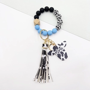 Detail of western cow print beads with Mama pendant and turquoise fringe on keychain