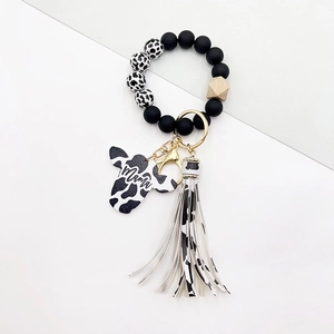Detail of Western style cow print keychain with Mama bull head charm and leather tassel