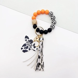 Detail of cow print keychain bracelet with Mama bull head pendant and fringe tassel