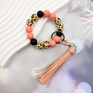 Detailed shot of leopard print silicone beads and orange tassel on a keychain bracelet