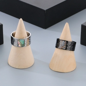Detail of wide stainless steel ring featuring hammered texture and abalone shell inlay
