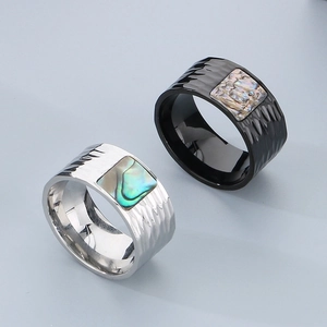 Macro detail of men's wide stainless steel rings with abalone shell inlay and hammered finish