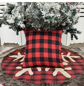 Detail of red plaid Christmas pillow cover and tree skirt with snowflake embroidery
