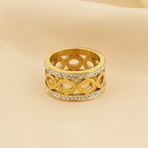Golden cutout hollow circle ring with pavé rhinestones on beige fabric background
