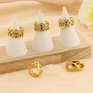 Golden infinity and heart cutout rings with sparkling zircon inlay set on display