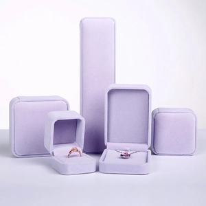 Group display of light purple velvet jewelry boxes for rings and necklaces on white background