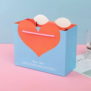 Blue paper gift bag with orange heart pattern and pink woven handles for Mother's Day