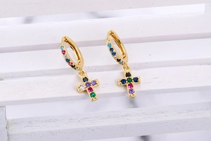 Close-up of golden cross earrings with colorful rainbow cubic zirconia inlays