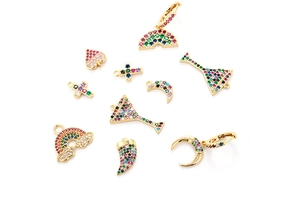 Detailed macro of gold plated earrings featuring rainbow and heart shaped zircon charms