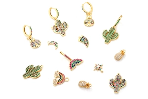 Flat lay of colorful crystal stud earrings with cactus, rainbow and pineapple shapes
