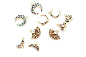 Close-up of gold-plated charms including crown and moon with colorful zircons