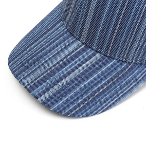Detailed close-up of striped baseball cap brim showing textured denim and fine stitching