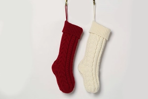 Detail of red and cream knitted Christmas stockings with classic cable stitch patterns
