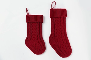 Close-up of deep red cable knit Christmas stockings with hanging loops on white background