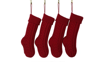 Close-up of four red cable knit Christmas stockings with hanging loops for holiday decor