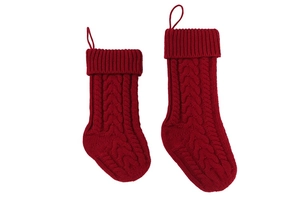 Detail of red cable-knit Christmas stockings with thick wool texture and hanging loops