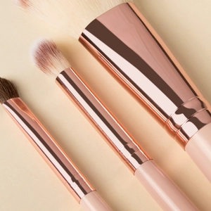 Detail of pink makeup brushes with rose gold ferrules and soft gradient bristles