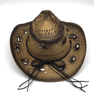 Dettaglio della trama traforata e del laccio con perle di legno sul cappello di paglia