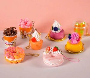 Close-up of assorted mini resin dessert charms including colorful donuts and popcorn