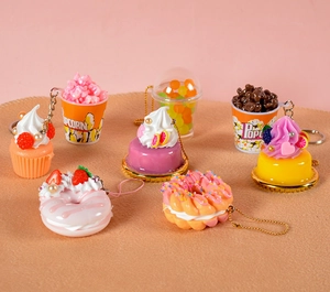 Detailed macro view of assorted miniature PVC food keychains with colorful dessert charms