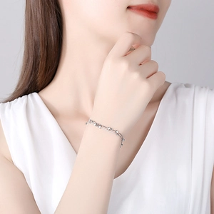 Double-layer 925 sterling silver star bracelet with cross pendant on model wrist