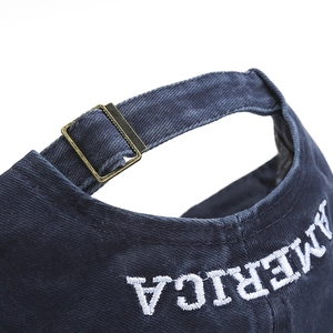 Detail of AMERICA embroidery and adjustable metal buckle on navy cotton baseball cap