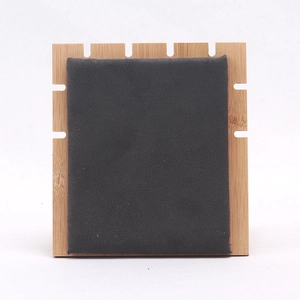Detail view of a bamboo jewelry display stand with gray velvet panel and side notches