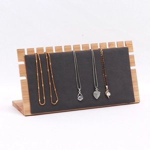 Bamboo necklace display stand with grey velvet surface and multiple hanging slots