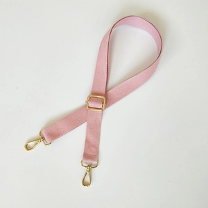 Détail de la bandoulière en coton rose avec boucle dorée et mousquetons pour sacs