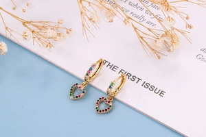 Detailed macro view of gold heart hoop earrings with vibrant multi-colored zircon stones