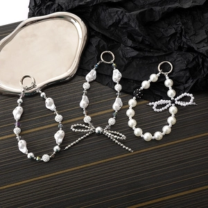 Detail of beaded keychains with faux pearls, rhinestone balls, and bow charms