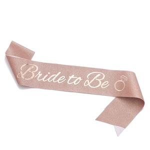 Detail of rose gold glitter sash featuring white Bride to Be text and ring icon