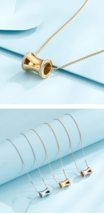 Close-up of cylindrical cylinder pendants in gold, silver and rose gold with pavé crystals