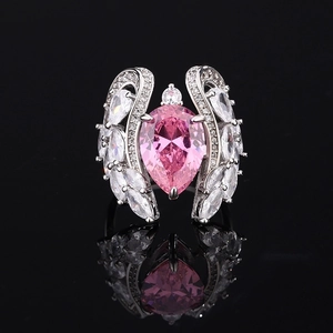 Exquisite silver ring featuring a large pear-cut pink gemstone and winged diamond accents