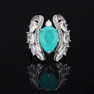 Macro shot of pear-cut turquoise ring with marquise zircon wing details on black base