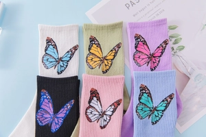 Flat lay of six colorful butterfly patterned ribbed cotton crew socks for women