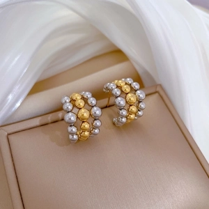 Minimalist titanium steel C-hoop earrings with gold and silver beads on a jewelry box