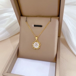 Elegant gold titanium necklace featuring a hollow flower pendant with cubic zirconia inlay