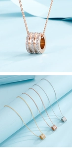 Close-up of triple cylinder necklaces with sparkling pavé crystals in three metallic tones