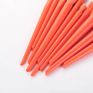 Detail of 10 orange candy-colored makeup brushes showing handles and soft bristles